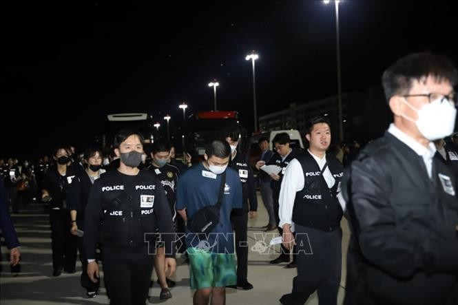 Korean nationals involved in technology-based fraud are handed over at the international airport in Phnom Penh on the evening of October 17, 2025. (Photo: AKP/VNA)