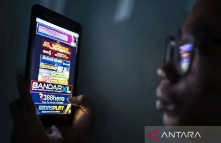 A man looks at an online gambling advertisement on a mobile phone screen in Jakarta. (Photo: Antara)