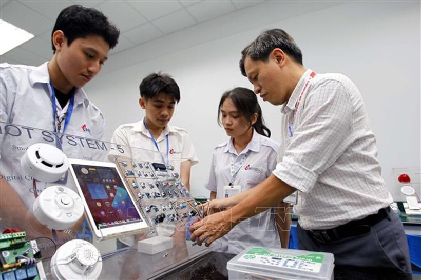 A lecturer from the Faculty of Electronics Technology at the Industrial University of Ho Chi Minh City guides students in study and research at the IoT and AI laboratory. (Photo: VNA)