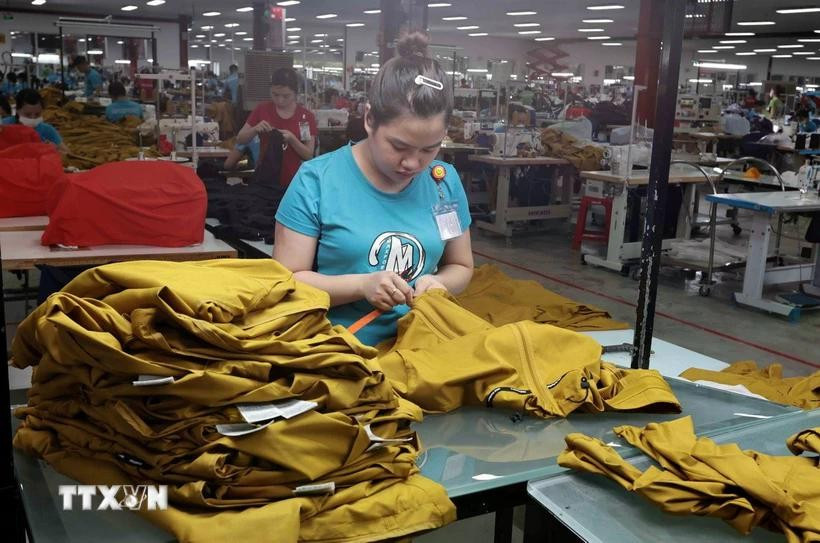 At a garment and textile firm (Photo: VNA)
