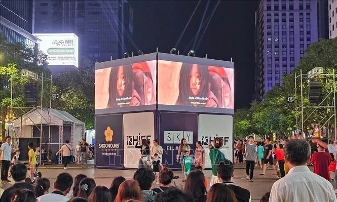 A large LED screen is set up on Nguyen Hue pedestrian street in District 1, HCM City, to enhance movie-watching experience for local residents. (Illustrative photo)