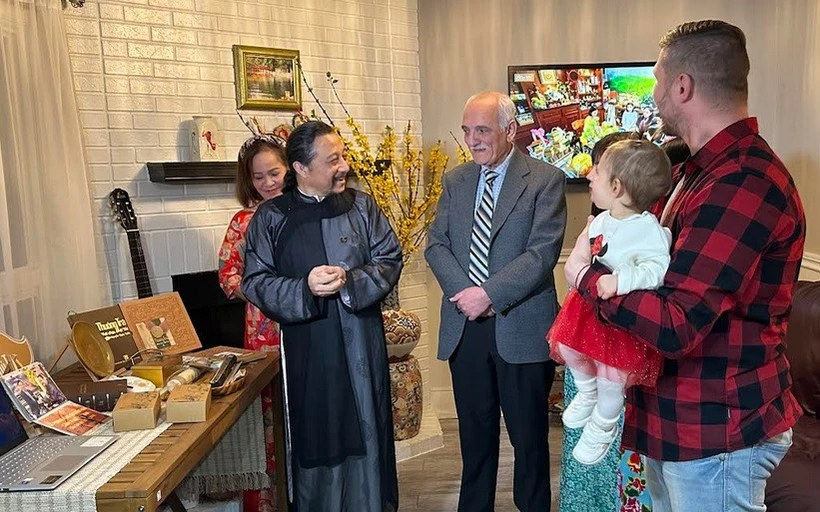 Artisan Nguyen Ngoc Tuan (in traditional ao dai) introduces Vietnamese tea to foreign friends. (Photo: VNA)