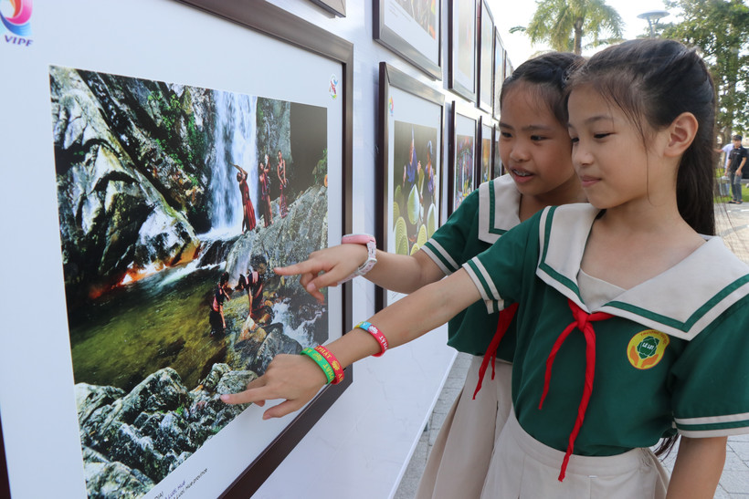 Visitors at the photo exhibition “Vietnam Through the Lens of International Photographers” (Photo: VNA)