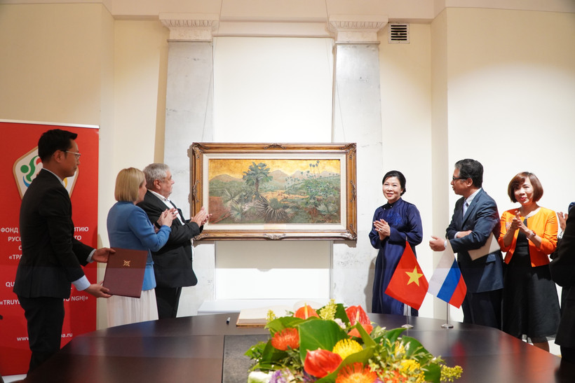 Madame Ngo Phuong Ly presents Doi co (hill of palms) painting to the State Museum of Oriental Art. (Photo: VNA)