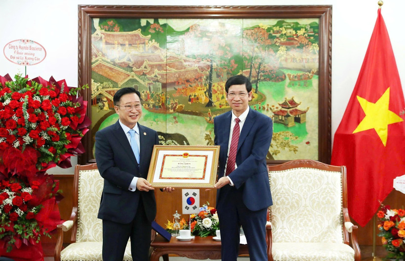 Deputy Minister of Culture, Sports and Tourism Ho An Phong presents a certificate of merit to Ly Xuong Can for his contributions to promoting tourism cooperation between the two countries. (Photo: VNA)