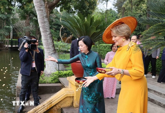 Queen Mathilde joins First Lady Nguyen Thi Minh Nguyet in feeding fish in Uncle Ho’s pond at the President Ho Chi Minh Memorial Site on April 1. (Photo: VNA)