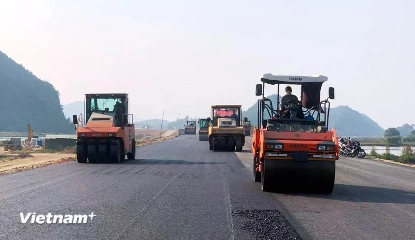 A contractor lays asphalt pavement for a section of the North-South Expressway project. (Photo: VietnamPlus)