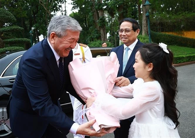 Kyrgyz PM Adylbek Kasimalyev receives flowers from a Hanoi kid at the welcome ceremony on March 6. (Photo: VNA)