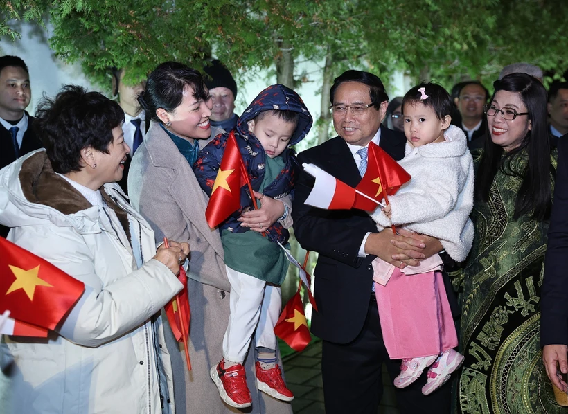 Prime Minister Pham Minh Chinh and his spouse meet with the staff of the Vietnamese Embassy and representatives of the Vietnamese community in Poland on January 16 evening (local time). (Photo: VNA)