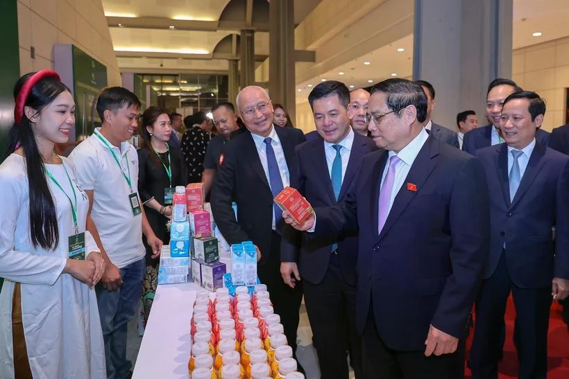 Prime Minister Pham Minh Chinh visits a booth of TH Group on the sidelines of the 9th announcement of products meeting national brand standards. (Photo: VietnamPlus)