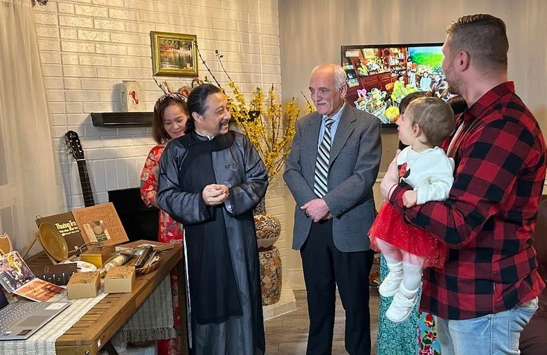 Artisan Nguyen Ngoc Tuan (in traditional ao dai) introduces Vietnamese tea to foreign friends. (Photo: VNA)