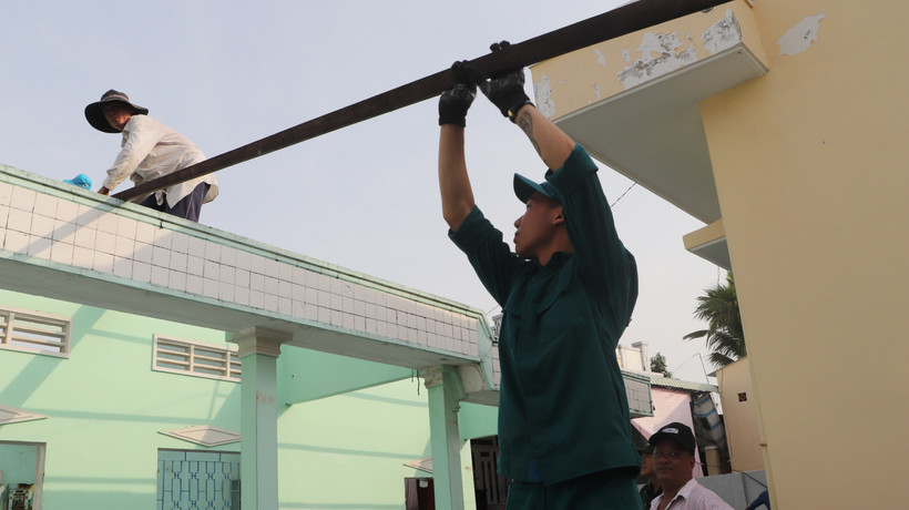 Long My township's armed forces assist residents in eliminating temporary and dilapidated houses. (Photo: VNA)