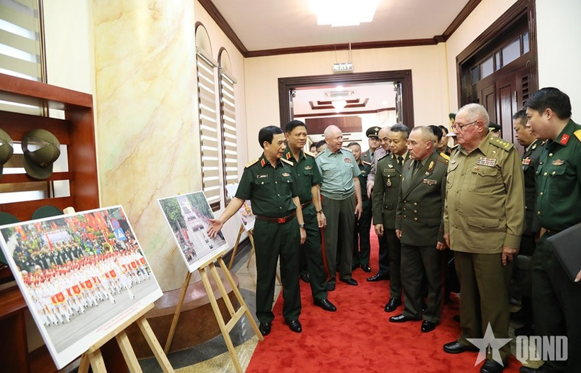 General Phan Van Giang presents foreign defence and military leaders with a photo exhibition showcasing activities commemorating the 80th anniversary of the August Revolution and National Day on September 2. (Photo: qdnd)
