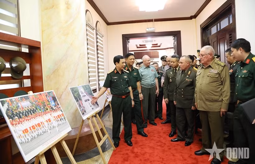 General Phan Van Giang presents foreign defence and military leaders with a photo exhibition showcasing activities commemorating the 80th anniversary of the August Revolution and National Day on September 2. (Photo: qdnd)
