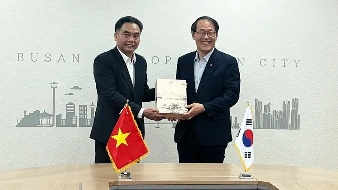 Vice Chairman of the HCM City People's Committee Nguyen Loc Ha (L) presents a commemorative gift to Busan Vice Mayor Lee Jun-seung. (Photo: Sggp)
