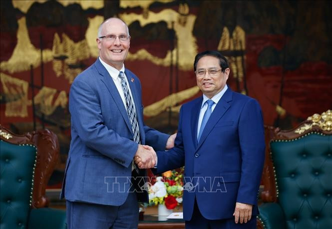 Prime Minister Pham Minh Chinh (R) and John Moolenaar, Congressman of Michigan state, head of the US House of Representatives’ bipartisan delegation. (Photo: VNA)