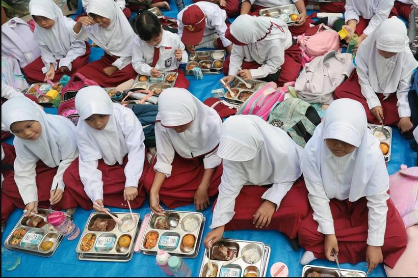 Students enjoying free meals at Lengkong 1 elementary school in Tangerang, Indonesia, on Jan 6. (Photo: EPA-EFE)