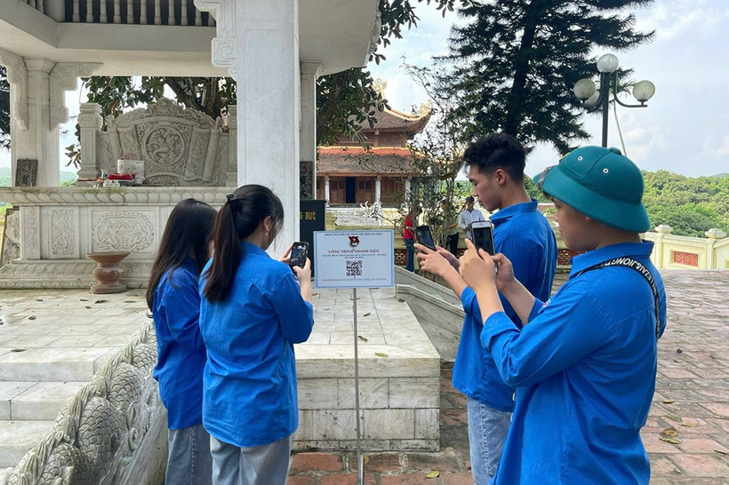 Youth union members in Ha Hoa township scan a QR code to learn about the Man Pagoda historical site. (Photo: baophutho)