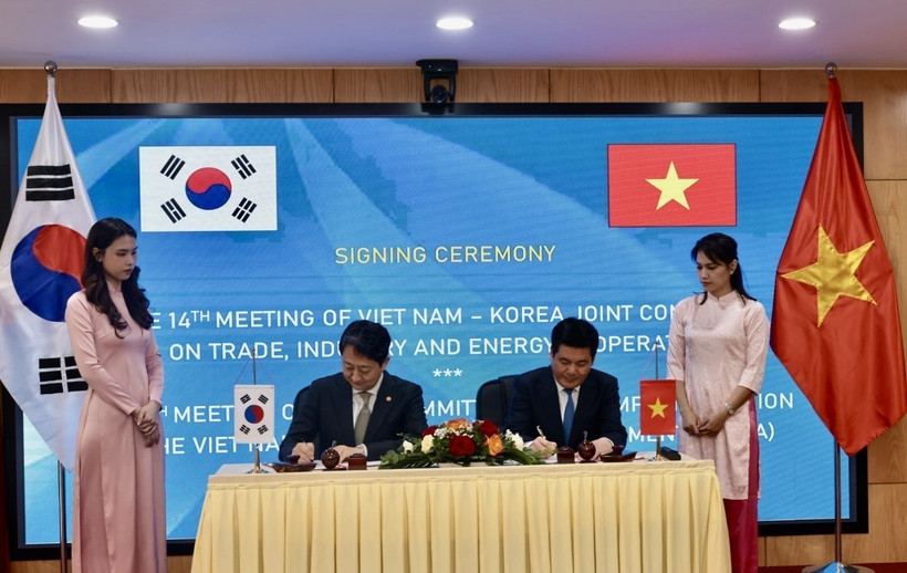 Vietnamese Minister of Industry and Trade Nguyen Hong Dien (R) and Korean Minister of Trade, Industry and Energy Ahn Dukgeun sign cooperation documents in the meeting. (Photo: VNA)
