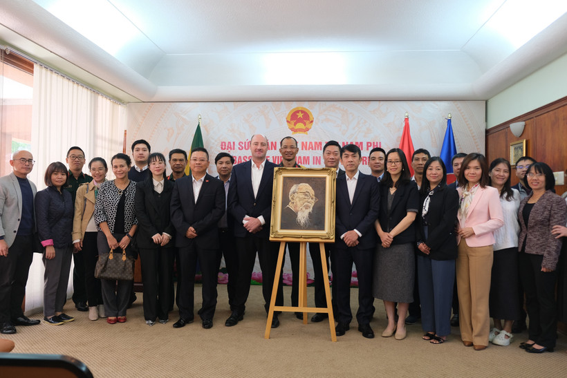 Vietnamese Ambassador to South Africa Hoang Sy Cuong and other delegates pose for a commemorative photo with the family of South African artist Jan van Rooyen beside his oil portrait of President Ho Chi Minh. (Photo: VNA)