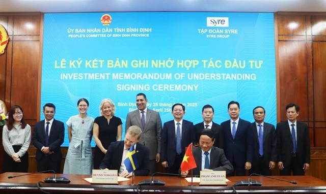 Chairman of the Binh Dinh provincial People’s Committee, Pham Anh Tuan (sitting, right), and the CEO of Syre Group sign a memorandum of understanding on investment cooperation on April 25. (Photo: nld)