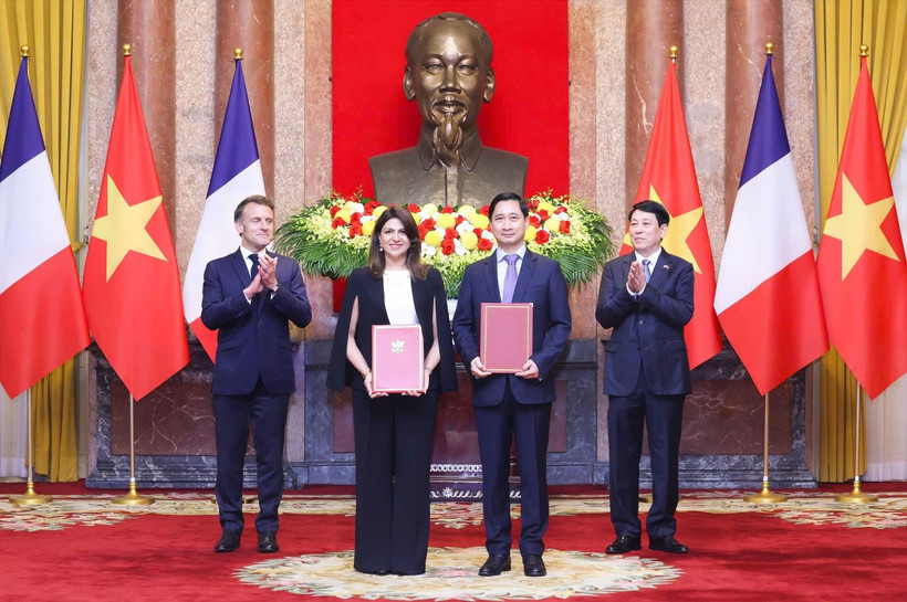On the morning of May 26, 2025, following bilateral talks at the Presidential Palace, President Luong Cuong (first, right) and French President Emmanuel Macron (first, left) witness the exchange of cooperation documents between leaders of ministries, agencies, and enterprises from both countries. In the photo: Ngo Chi Dung, General Director and Chairman of the Board of Viet Nam Vaccine Company (VNVC) (second, right), and Zainab Sadat Qayyum, President of Sanofi Southeast Asia – India, exchange the cooperation agreement on the transfer of Sanofi’s vaccine production technology to VNVC’s vaccine and biologicals plant. (Photo: VNVC)