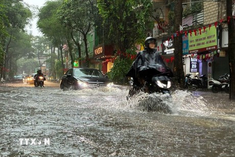 Heavy rain causes flooding on the streets. (Photo: VNA)