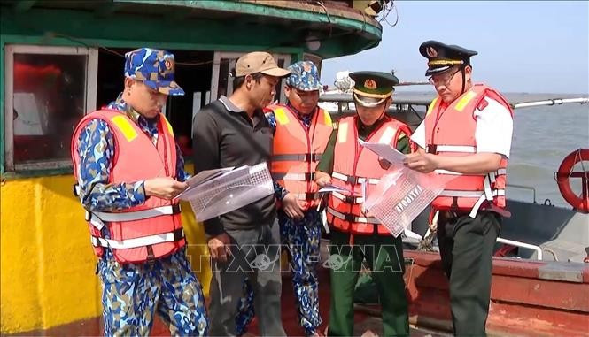 Officers and soldiers of the Ninh Binh Border Guard Command, in coordination with the provincial Sub-Department of Fisheries and the Department of Agriculture and Rural Development, disseminate anti-IUU fishingrules to fishermen working at sea. (Photo: VNA)
