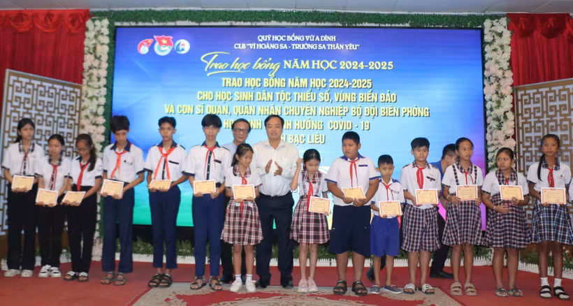 Students receive scholarships at the ceremony on March 25. (Photo: VNA)