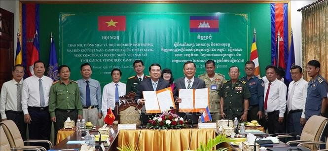 Vice Chairman of the An Giang provincial People’s Committee Le Trung Ho (left) and Deputy Governor of Kampot province Khiev Rithiphorn sign an agreement on the exchange, consensus, and implementation of the Vietnam–Cambodia Border Trade Agreement. (Photo: VNA)
