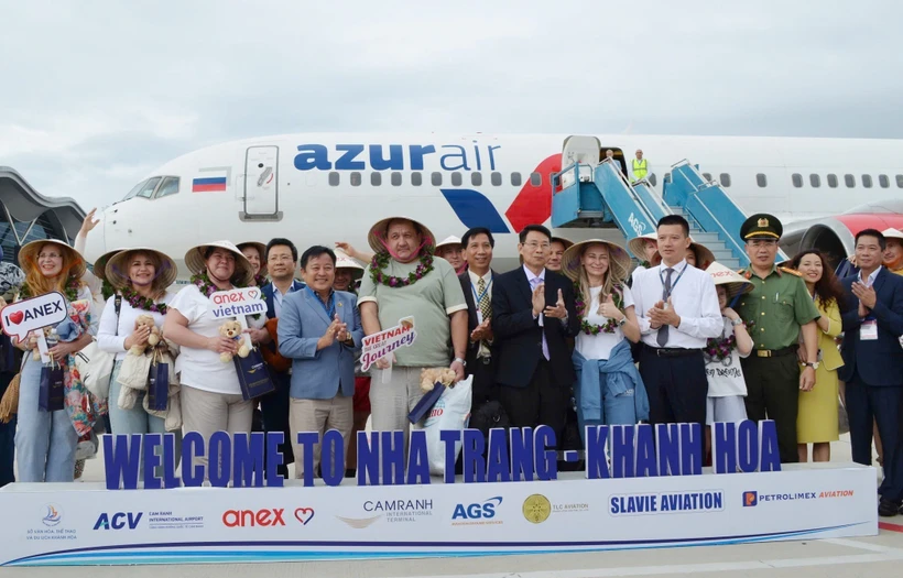 Russian tourists pose for photos with representatives from Khanh Hoa province (Photo: VNA)