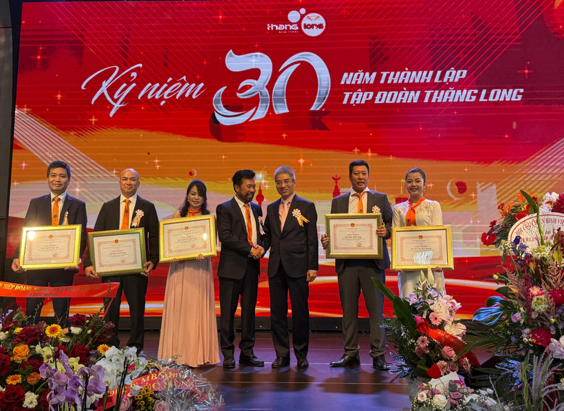 Vietnamese Ambassador to Germany Nguyen Dac Thanh (centre, right) and Vo Van Long, Chairman of Thang Long Group, pose for a commemorative photo with members of the group who received Certificates of Merit from the Embassy (Photo: VNA)
