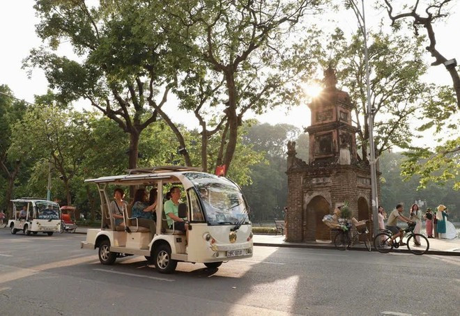 Tourists ride around Hoan Kiem Lake on electric shuttle vehicles. (Photo: VNA)