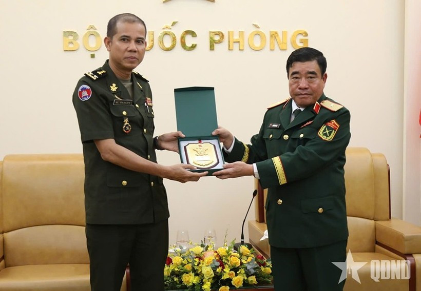 Major General Nguyen Ba Luc (R) presents a gift to Lieutenant General Nim Balene. (Photo: Qdnd.vn)