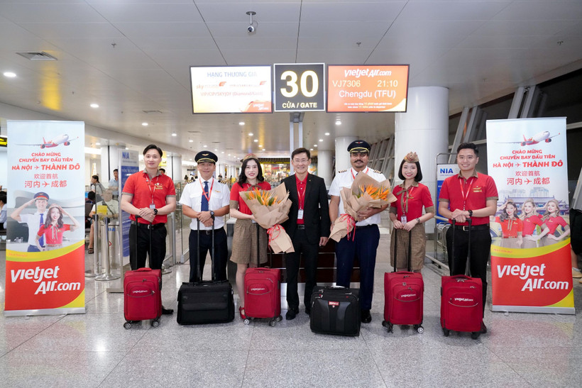 A leader of Vietjet welcomes the inaugural Hanoi – Chengdu flight alongside the flight crew and passengers at Noi Bai International Airport. (Photo: Vietjet)