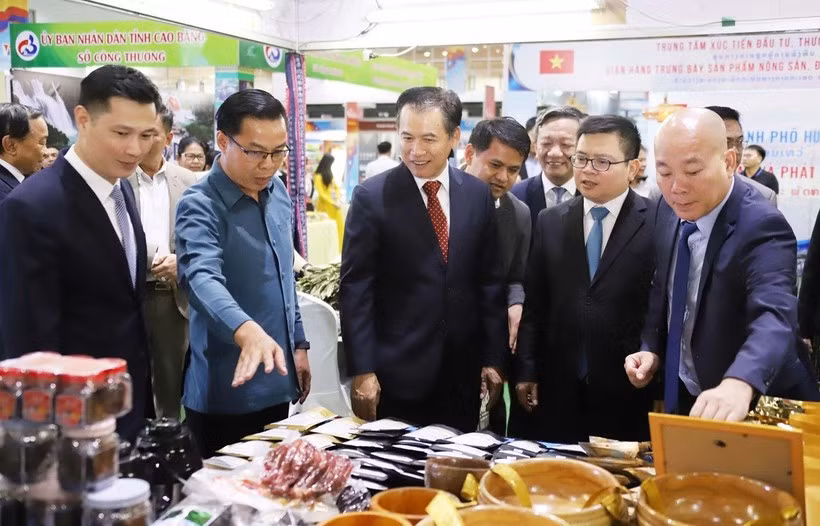 Vietnamese and Lao trade officials, along with other delegates, visit the Vietnamese pavilion at the trade fair. (Photo: VNA)