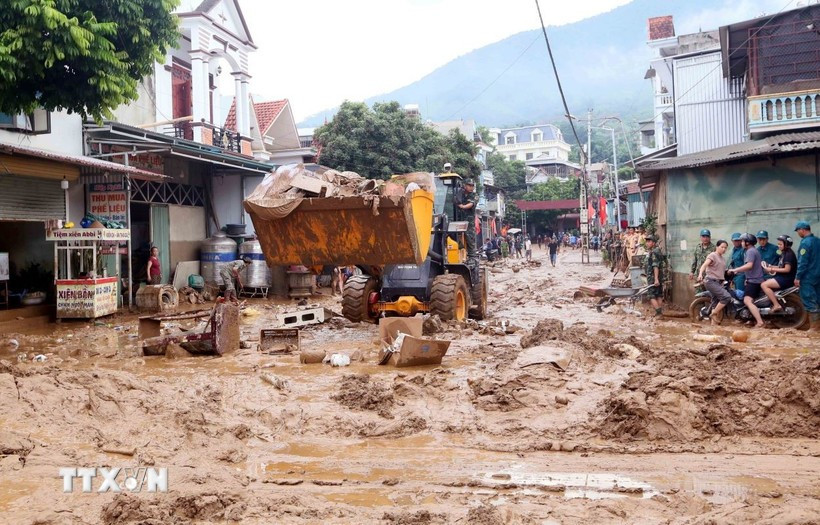 Excavators are deployed to help clear mud, fallen branches, and debris swept in by recent floods in Song Ma commune, Son La province. (Photo: VNA)