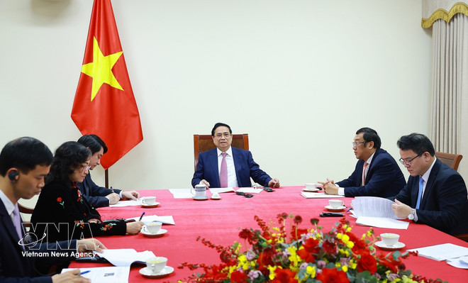 Prime Minister Pham Minh Chinh (C) holds phone talks with Angolan President Joao Manuel Goncalves Lourenco on March 16. (Photo: VNA)