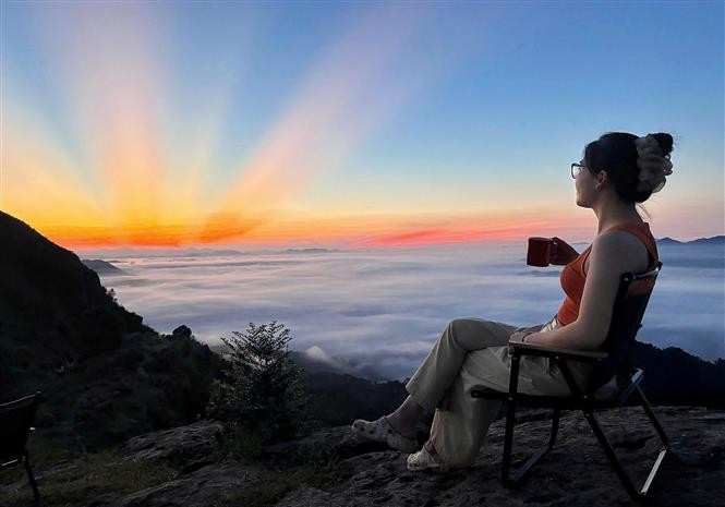 Visitors admiring the sunrise at Dong Cao Plateau. (Photo: VNA)