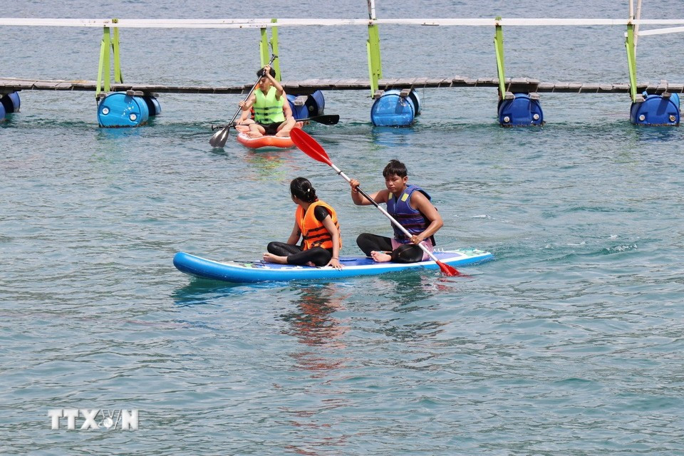 Tourists experience kayaking on Vinh Hy Bay. (Photo: VNA)