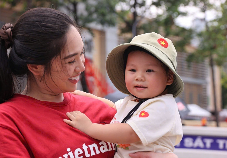 A child and her mother attend the rehearsal of the parade for the A80 celebration. (Photo: VNA)