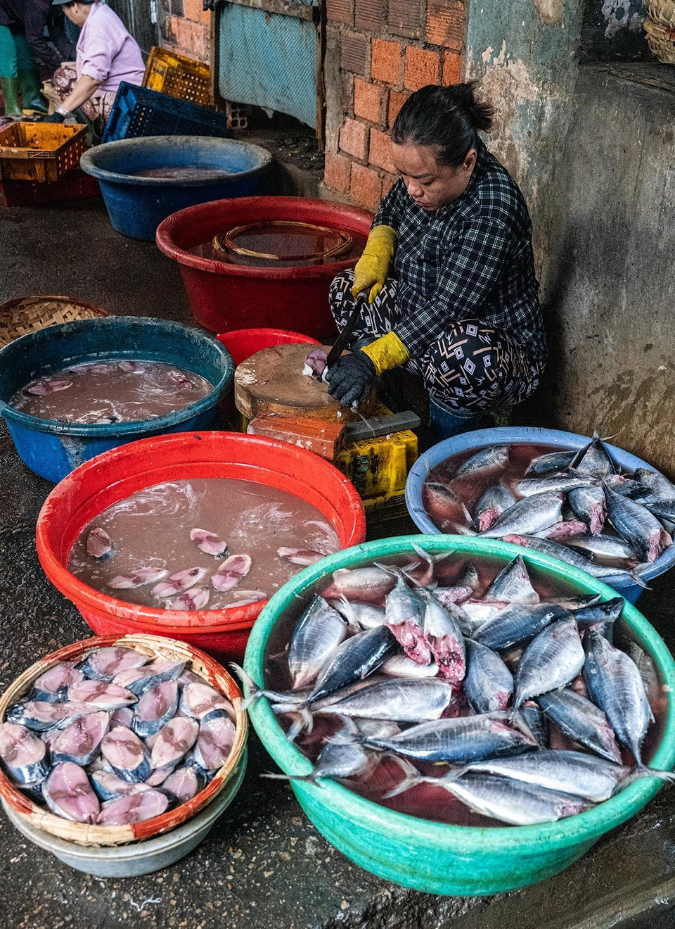 Cleaning the fish before placing them in the steamer. (Photo: VNA)