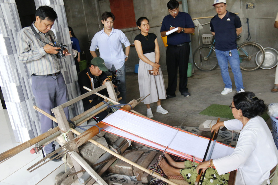 Tourists watching a demonstration of Cham brocade weaving. (Photo: VNA)
