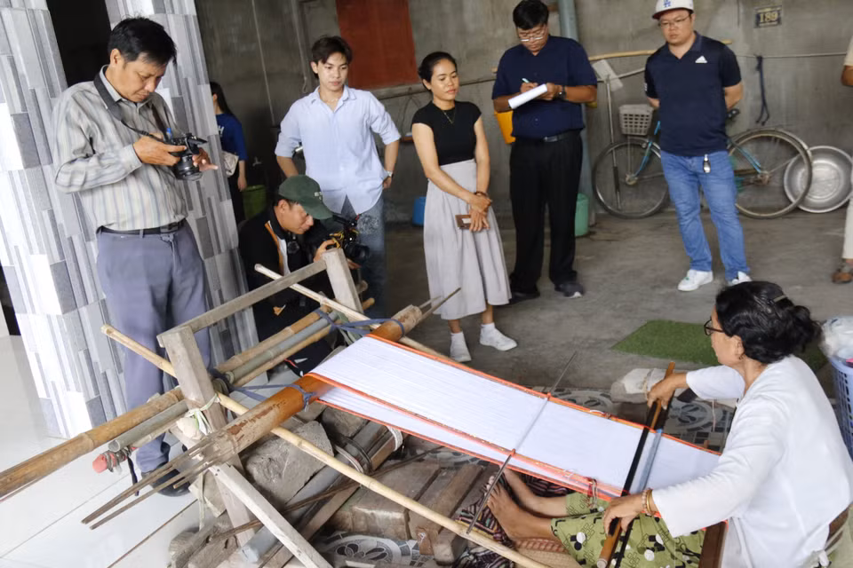 Tourists watching a demonstration of Cham brocade weaving. (Photo: VNA)