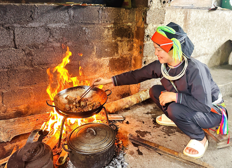 A Dao woman by the warm fire inside her moss-roofed house in Thanh Thuy. (Photo: VNA)