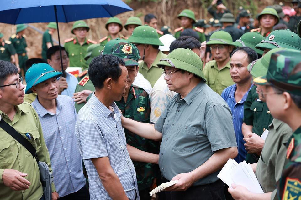 Prime Minister Pham Minh Chinh speaks with residents of Xa Dung commune affected by flooding. (Photo: VNA)