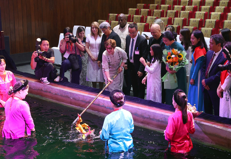 Madam Lis Cuesta Peraza, spouse of the Cuban President, tries performing with water puppets. (Photo: VNA)