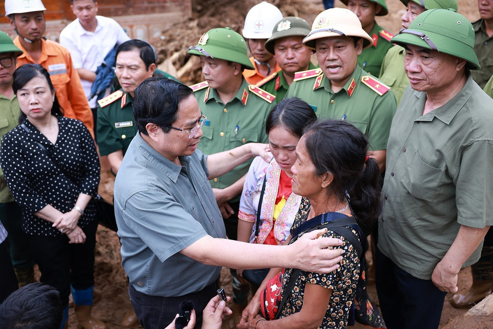 Prime Minister Pham Minh Chinh speaks with residents of Xa Dung commune affected by flooding. (Photo: VNA)