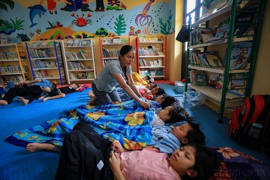 Vietnam is improving population quality through human rights-based and humane policies. In photo: A teacher cares for students in Rang Hamlet, Son Phu School (Hoa Binh). (Photo: VNA)