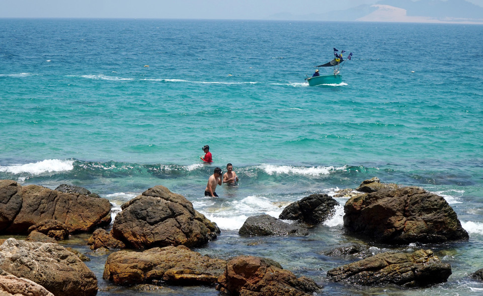 Tourists enjoy immersing themselves in the clear blue sea water next to Vi Rong Cape. (Photo: VNA)